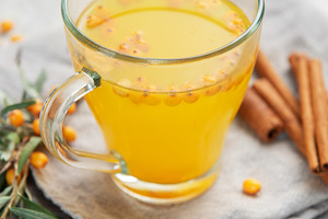 Sea buckthorn tea with berries and cinnamon sticks on grey napki, a Food & Drink Photo by Olena Rudo