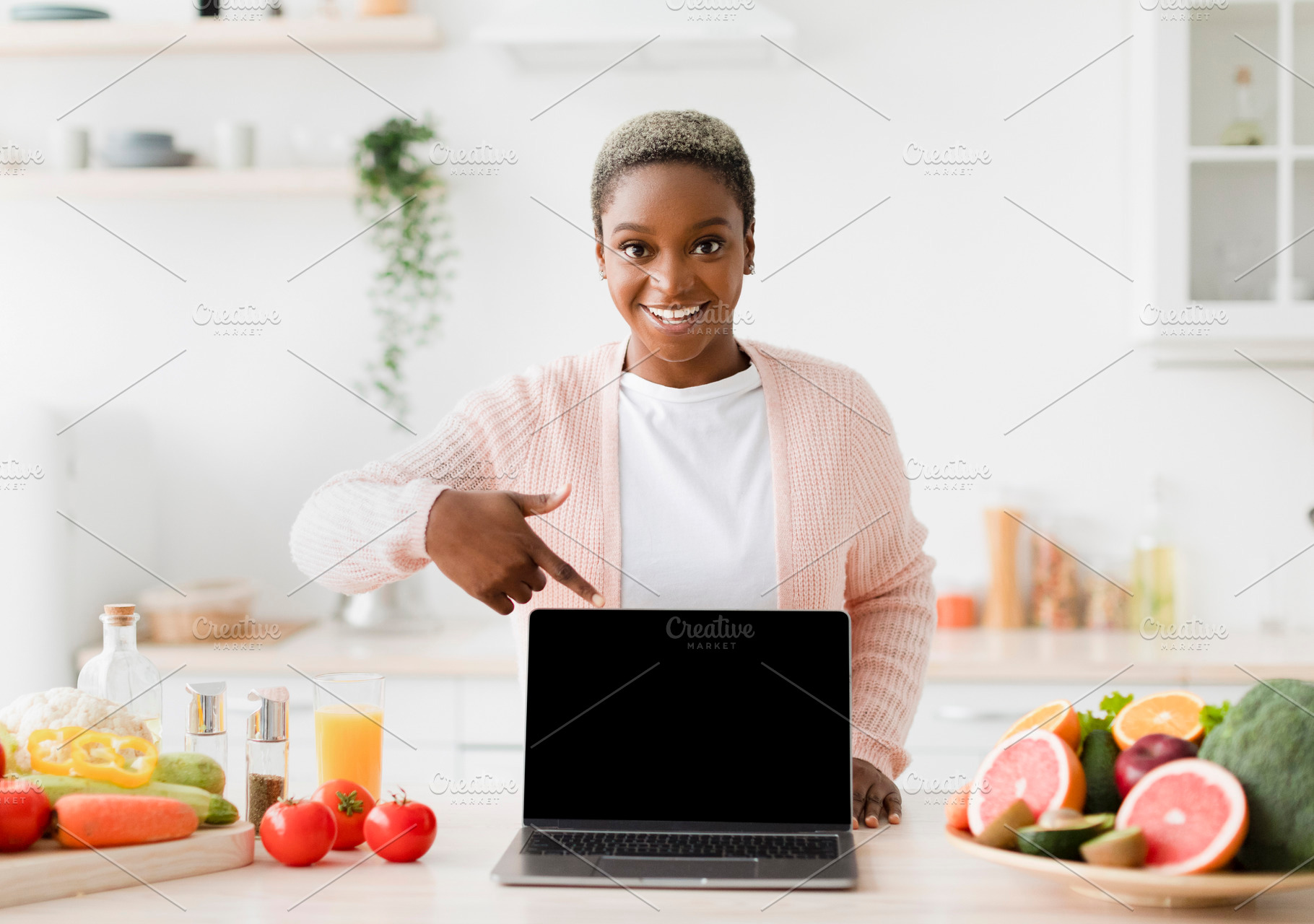 Happy glad excited young black female blogger points finger at pc with empty sc, a Person Photo by Prostock-Studio