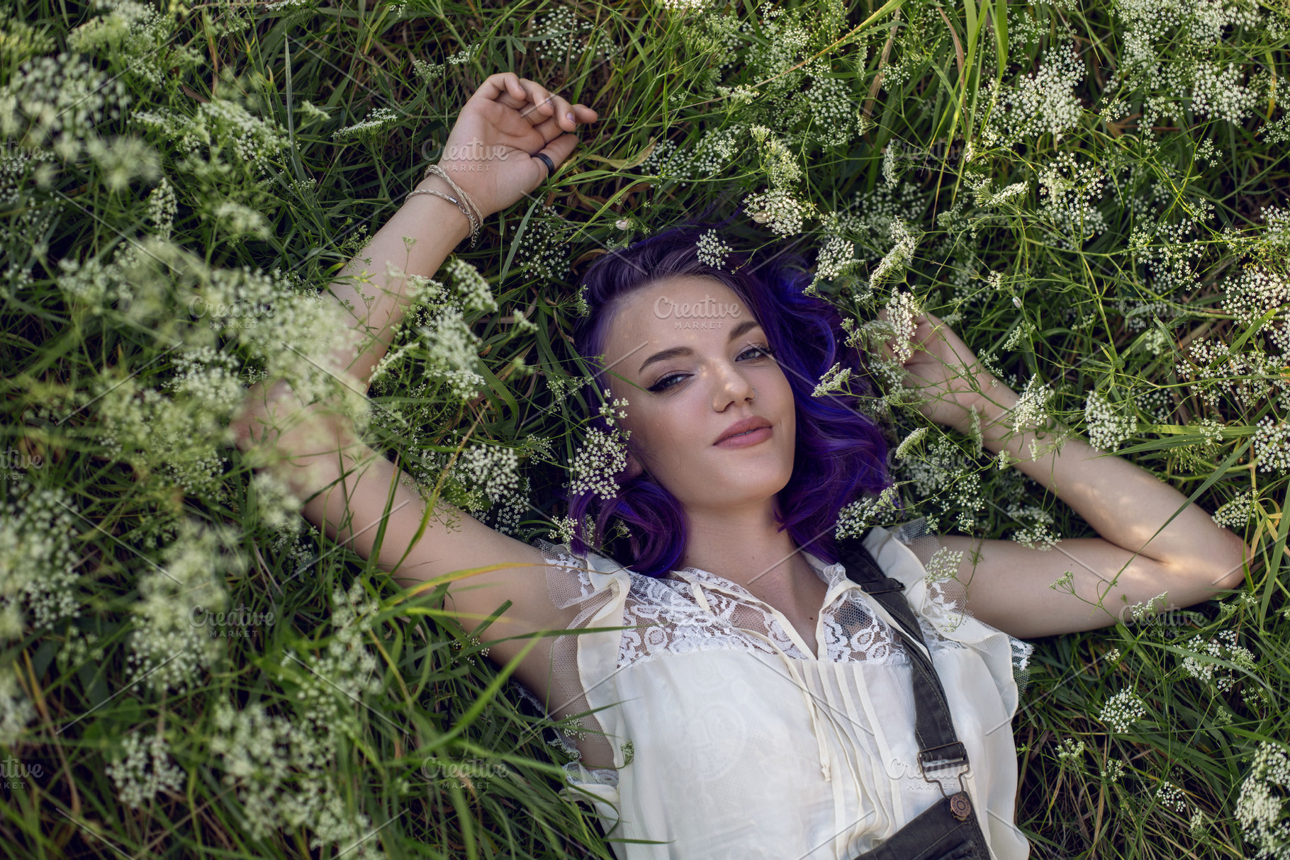 portrait of a teenage girl with purple hair and an earring in her nose lying in, a Person Photo by SaulichPhoto