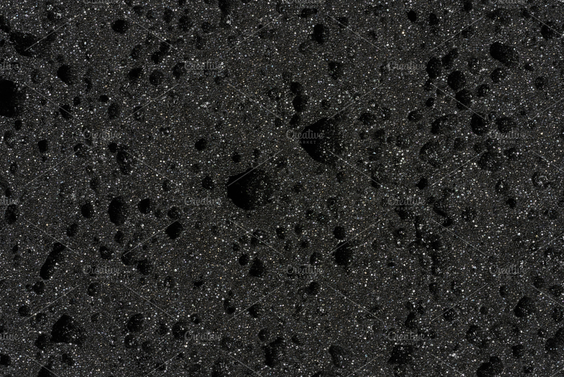 Close-up of black porous sponge with many small holes, an Abstract Photo by ndanko