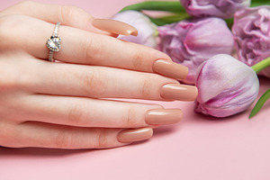 Woman showing nude manicure and engagement ring near tulips on p, a Beauty & Fashion Photo by Olena Rudo