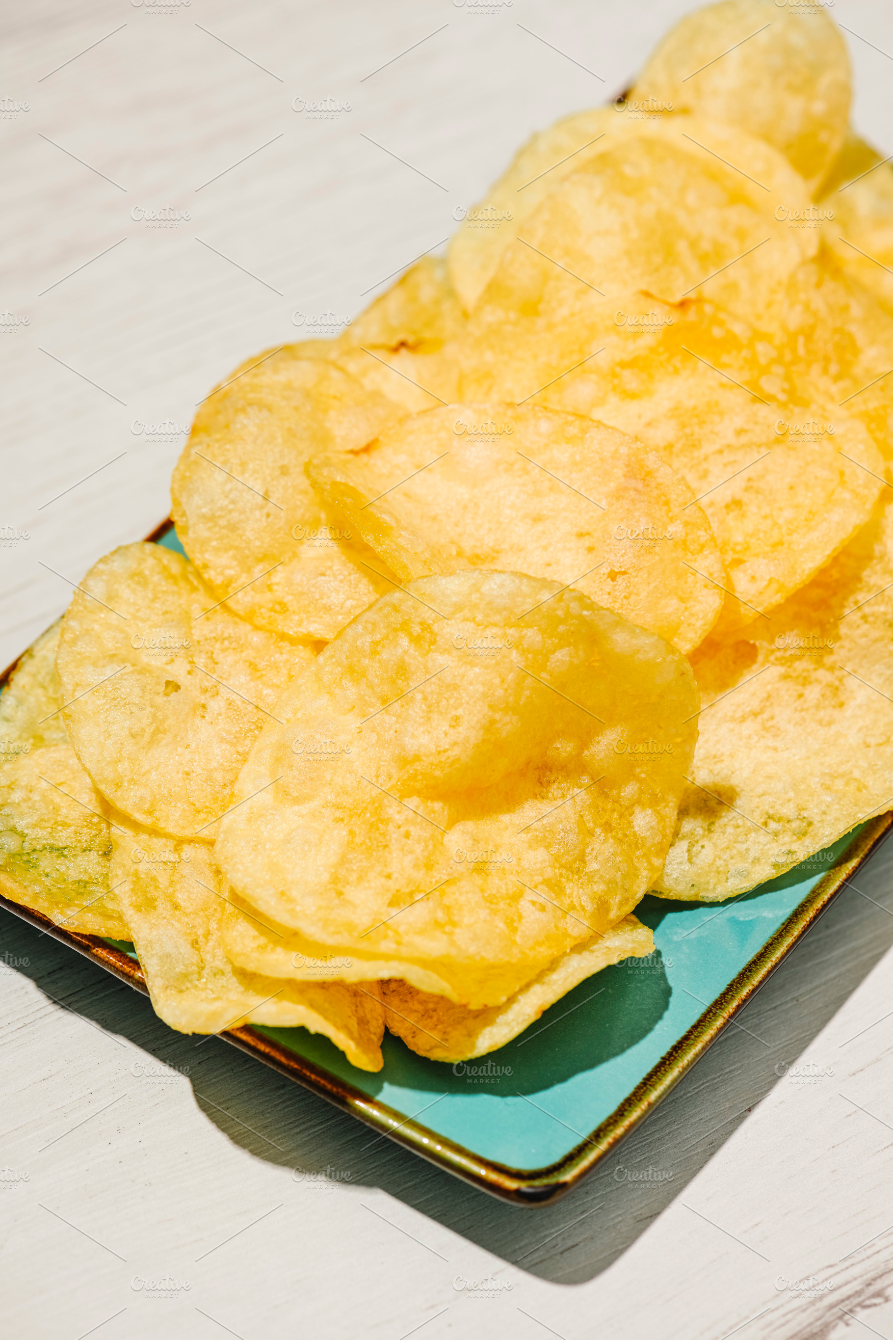 tightly framed potato chips on a turquoise plate, a Photo by Nito
