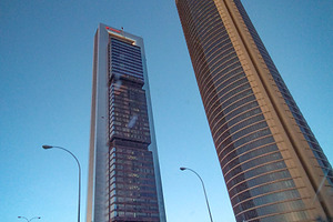 Tall skyscrapers with reflective glass under blue sky, an Architecture Photo by DanFLCreativo