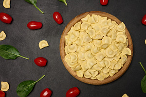 Uncooked tortellini pasta with fresh cherry tomatoes and spinach, a Food & Drink Photo by ndanko