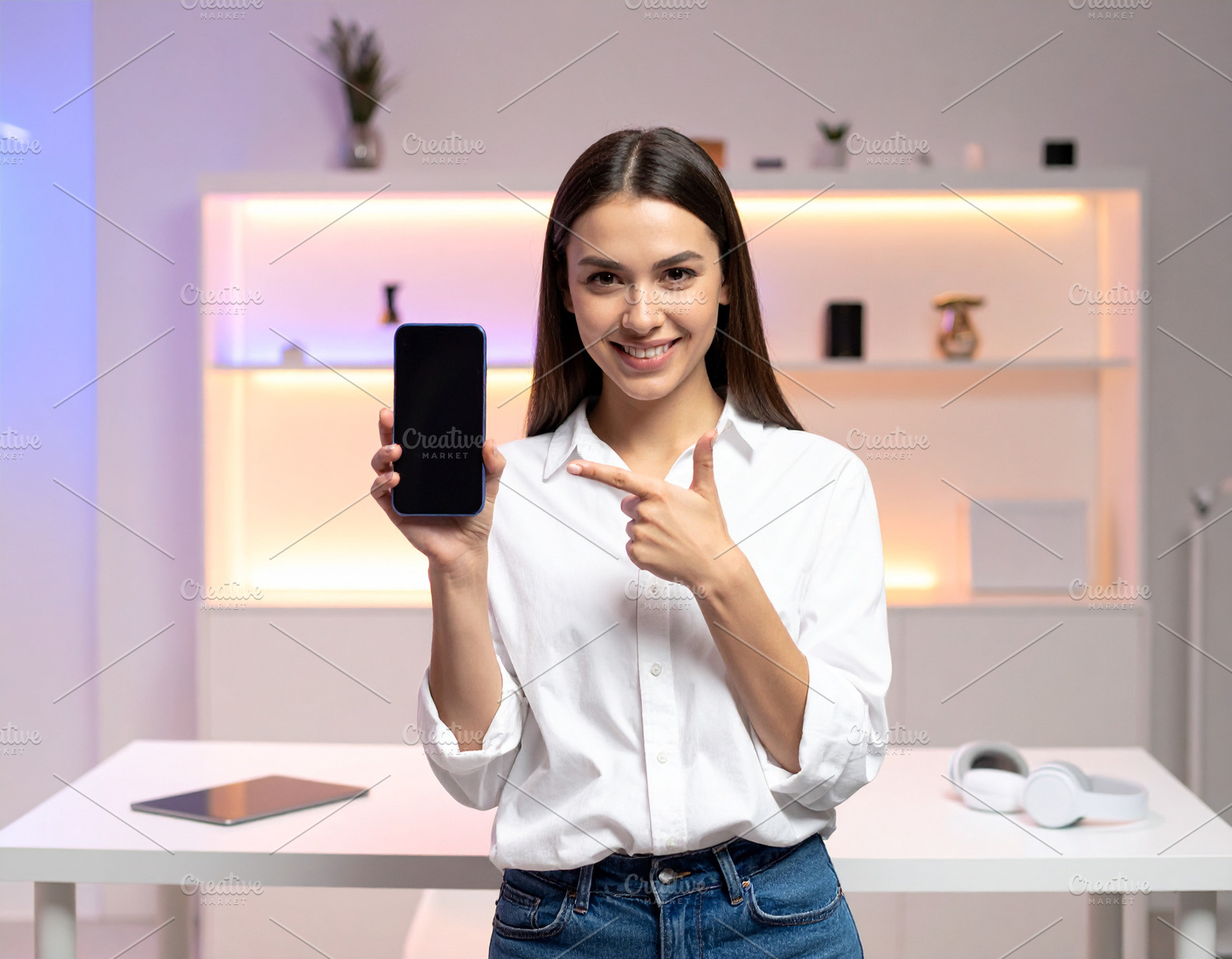 Woman content creator standing in a modern studio holding up a s, a Person Photo by DanFLCreativo