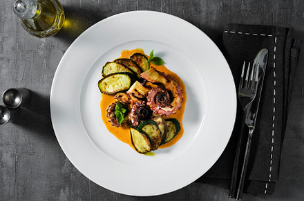 cooked octopus, served with courgettes and sauce serving on the