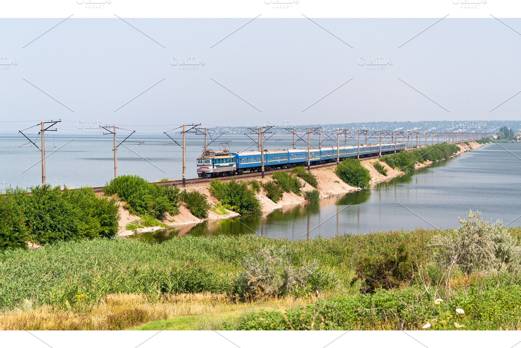 Passenger electric train on a dam, a Transportation Photo by Leonid Andronov