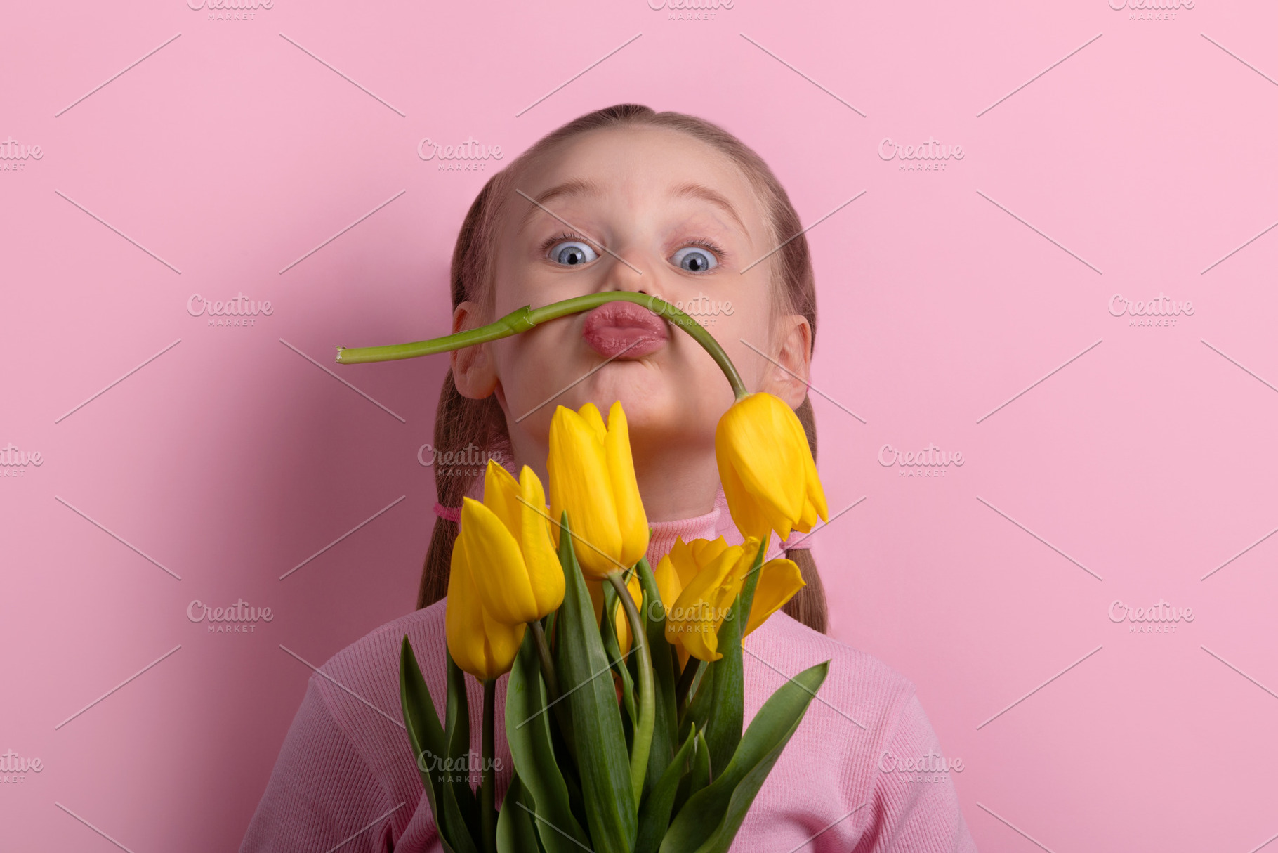 Smiling young girl holding yellow tulips, making a funny mustach, a Person Photo by Ales Munt