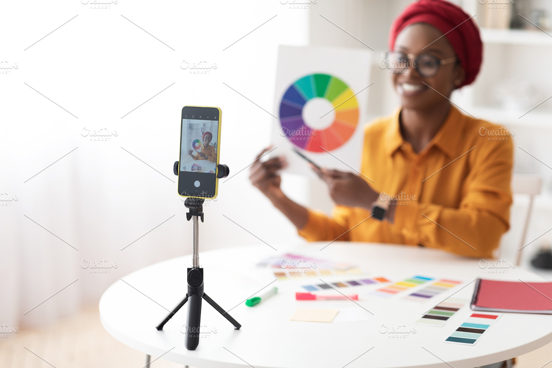 Selective focus on smartphone set on tripod, recording black lady, a Photo by Prostock-Studio