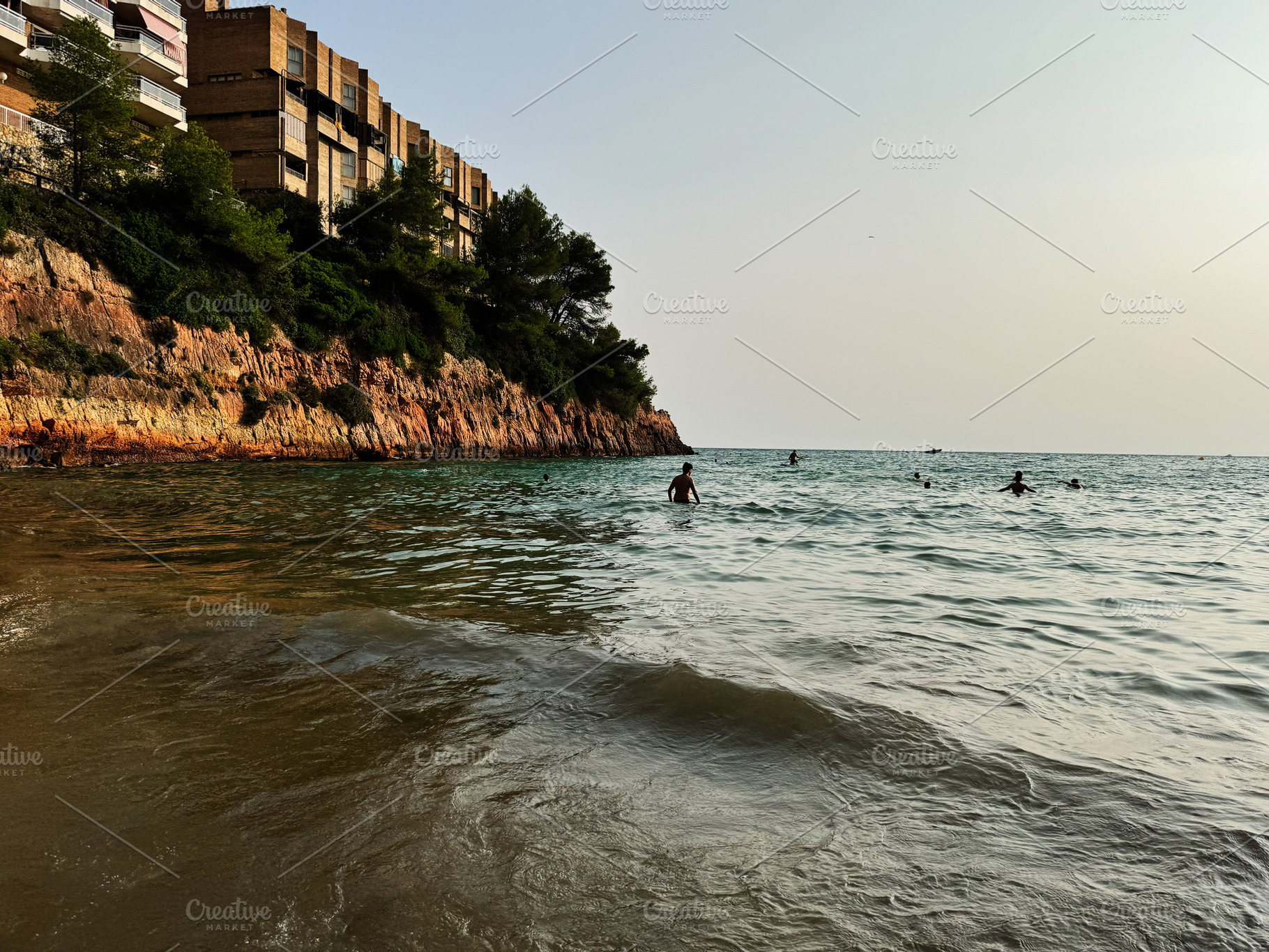 Beachside cliff view with swimmers in Salou, Tarragona, Catalonia, Spain, a Photo by AS photostudio