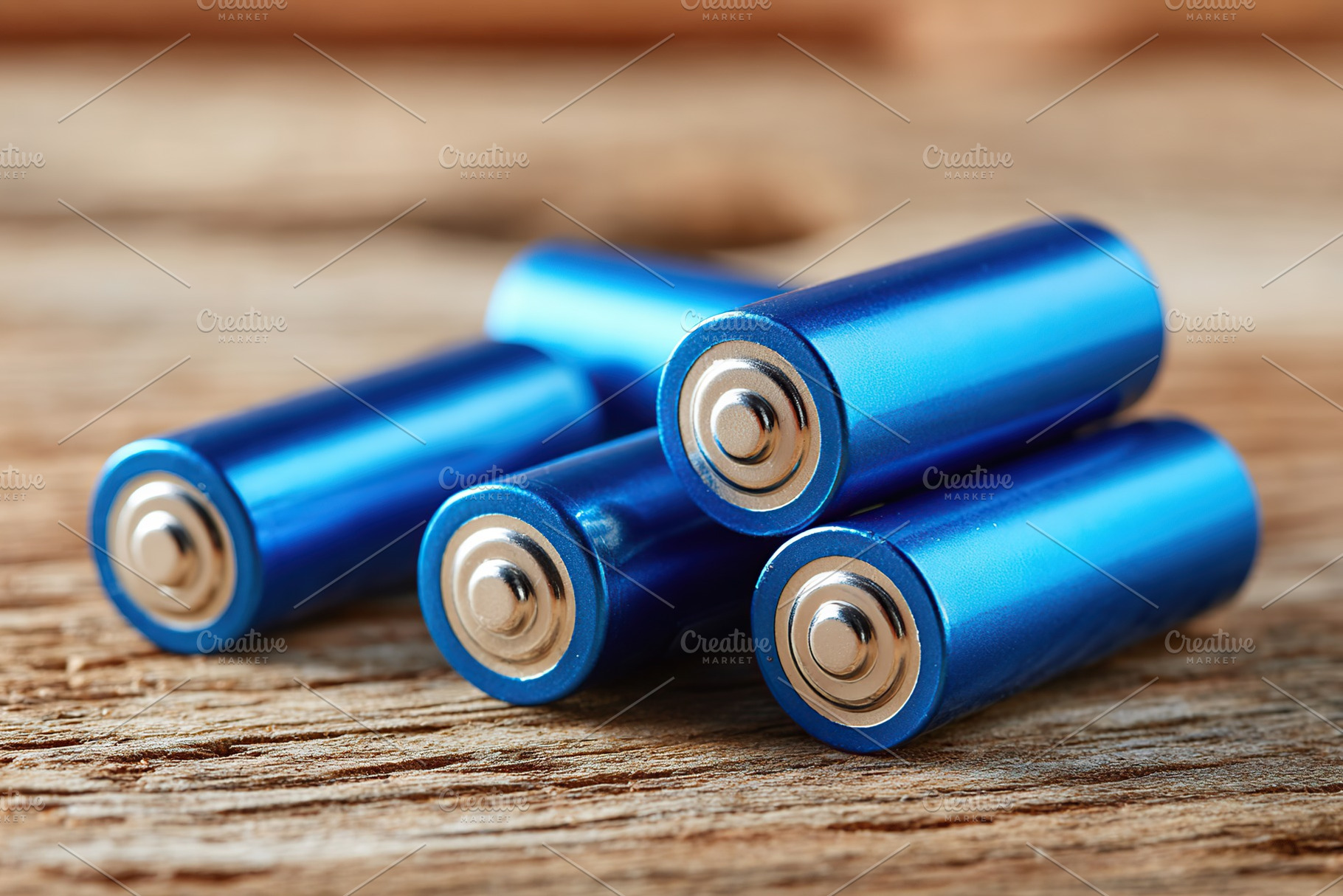 Blue batteries on wooden surface, a Technology Photo by AlyaAnd