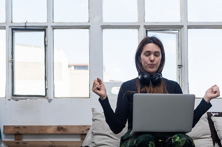 Beautiful Woman sitting on sofa and using laptop., a Person Photo by 2Design