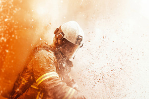 Firefighter battling blaze with intense smoke and debris, suitab, a Photo by Dvoevnore photos