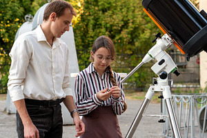 Student examines telescope part, a Person Photo by Elena Vagengeim