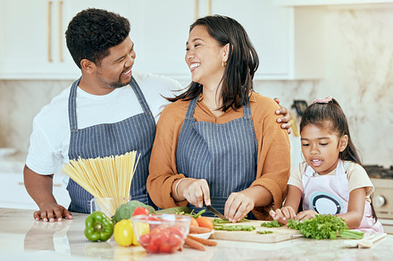 Cooking, kitchen and family with a girl, mother and father preparing food for a meal in their home together. Children, health and diet with a man, woman and daughter making dinner in a house, a Photo by Peopleimages.com