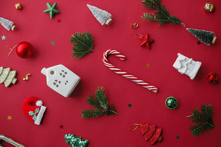 Stylish christmas festive decorations on red background flat lay, a Holiday Photo by Sonjachni