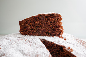 Slice of delicious caprese cake resting on top of the rest of the cake, a Food & Drink Photo by Antonio Gravante Market