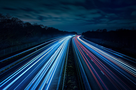 Vehicles travel along a busy highway, a Photo by Tanuart