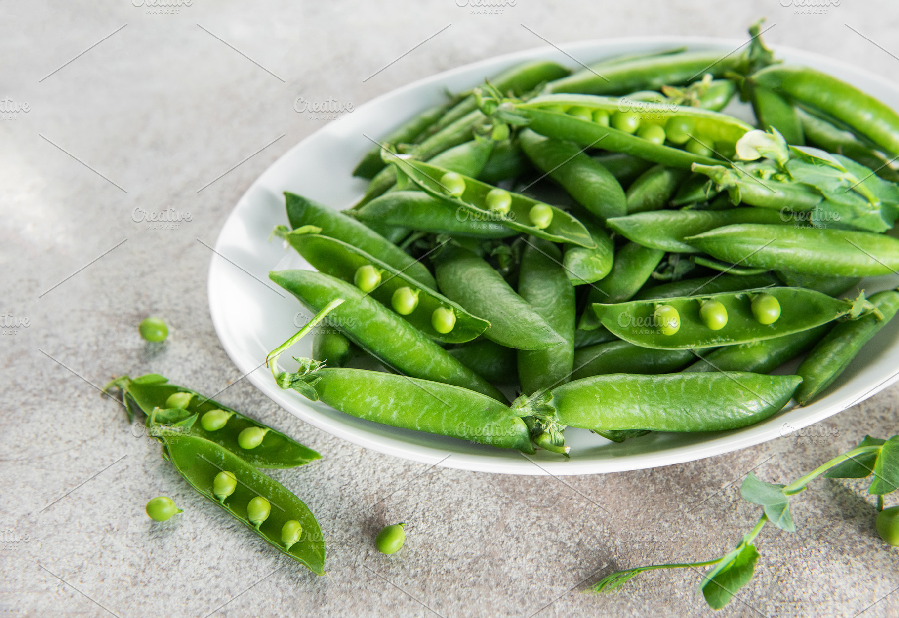 Fresh green peas and pods on white plate, a Food & Drink Photo by Olena Rudo
