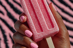 Frosted pink popsicle held by a hand with glossy light pink nail, a Photo by José Manuel Gelpi