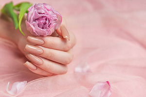 Woman hand with perfect nude manicure holding pink flower on pin, a Beauty & Fashion Photo by Olena Rudo