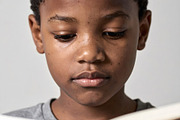 Young boy reading book with calm focused expression, a Person Photo by GoodGoods (Thumbnail 2 of 2)