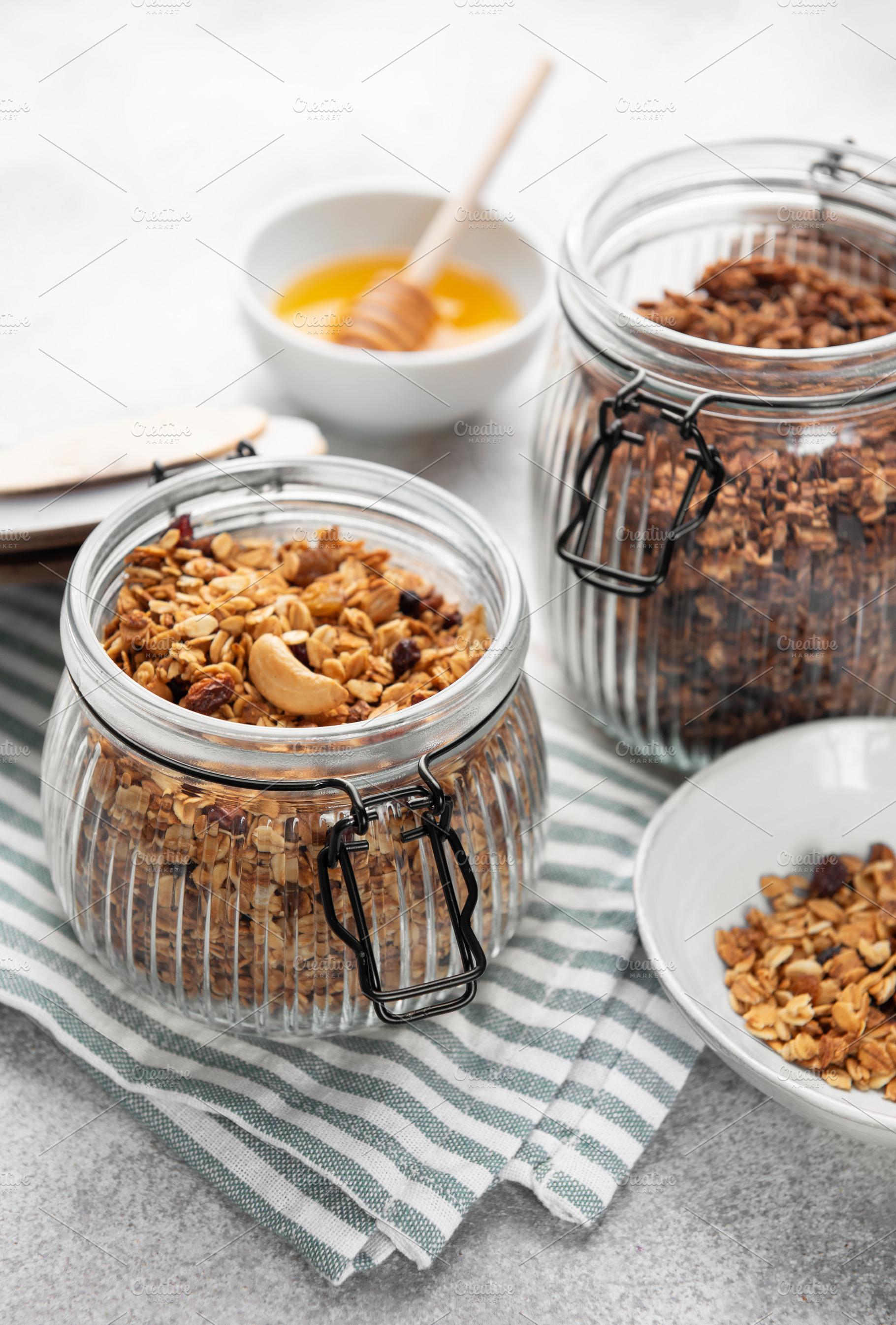 Granola with nuts and dried fruits in glass jars, a Food & Drink Photo by Olena Rudo