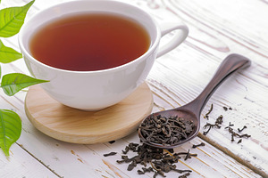 White cup of aromatic tea on wooden table, a Food & Drink Photo by AlyaAnd