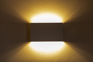 Modern wall lamp illuminating textured wall with warm light, an Architecture Photo by Antonio Gravante Market