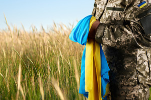 Ukrainian soldier in camouflage uniform holding the flag of Ukra, a Person Photo by ndanko