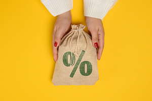 Female hands in a white knitted sweater holding a burlap bag wit, a Business Photo by ndanko