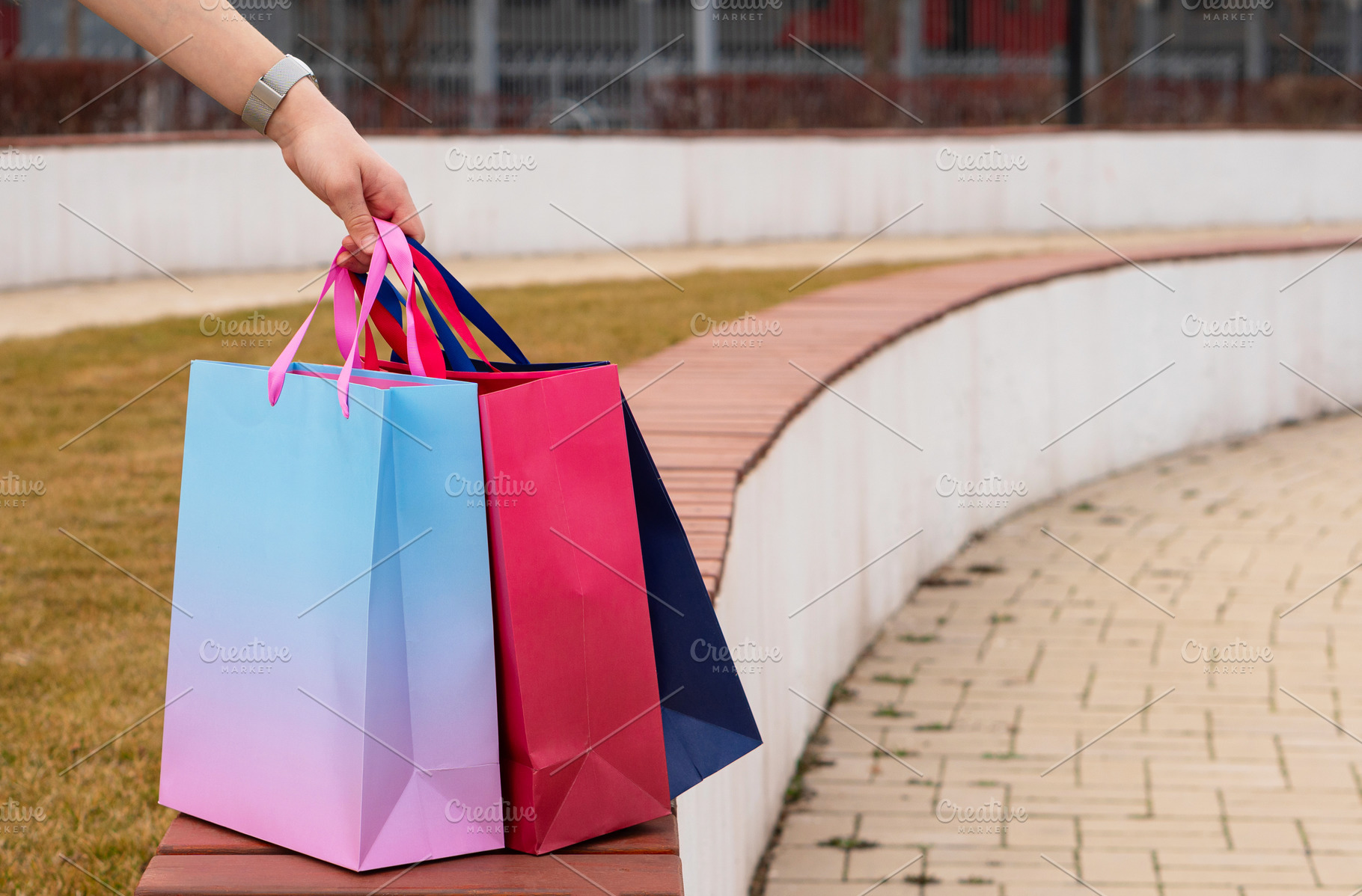 Hand holding three colorful shopping, a Background Photo by Elena Vagengeim