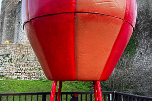Child exploring a red balloon model near historic castle in Obidos, Portugal, a Photo by AS photostudio