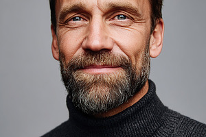 Portrait of an attractive man with a beard in a studio setting wearing a dark s, a Person Photo by AlyaAnd