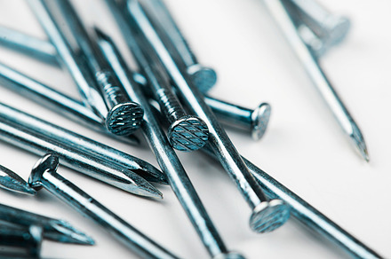 Close-up of nails stacked on white background. Isolated., an Industrial Photo by José Luis Agudo