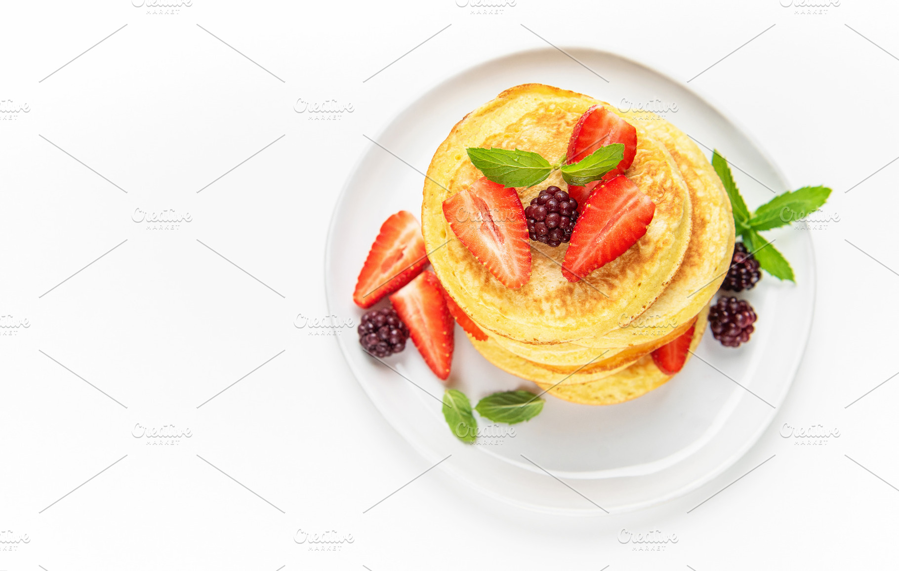 Pancakes stack with fresh berries and mint leaves, a Food & Drink Photo by Olena Rudo
