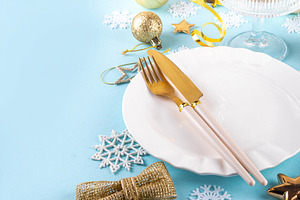 Christmas, New Year table setting with plate, drinking glass, cu