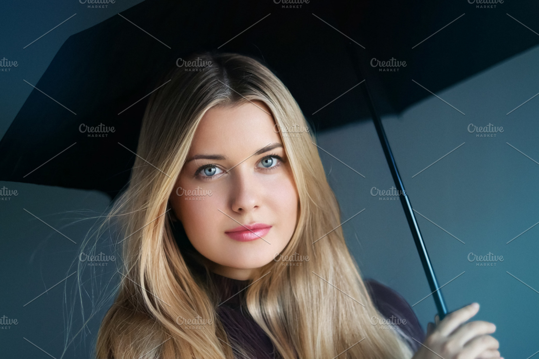 Blonde woman holding a black umbrella, looking directly forward., a Person Photo by Studio ANNA