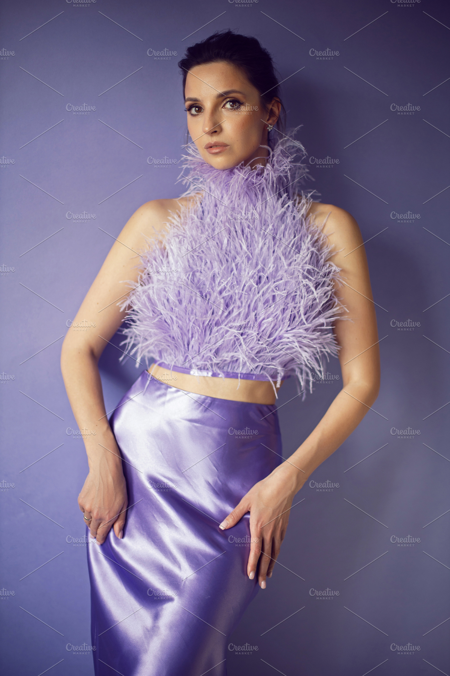 portrait woman in an evening purple dress with feathers stands in the backgroun, a Person Photo by SaulichPhoto