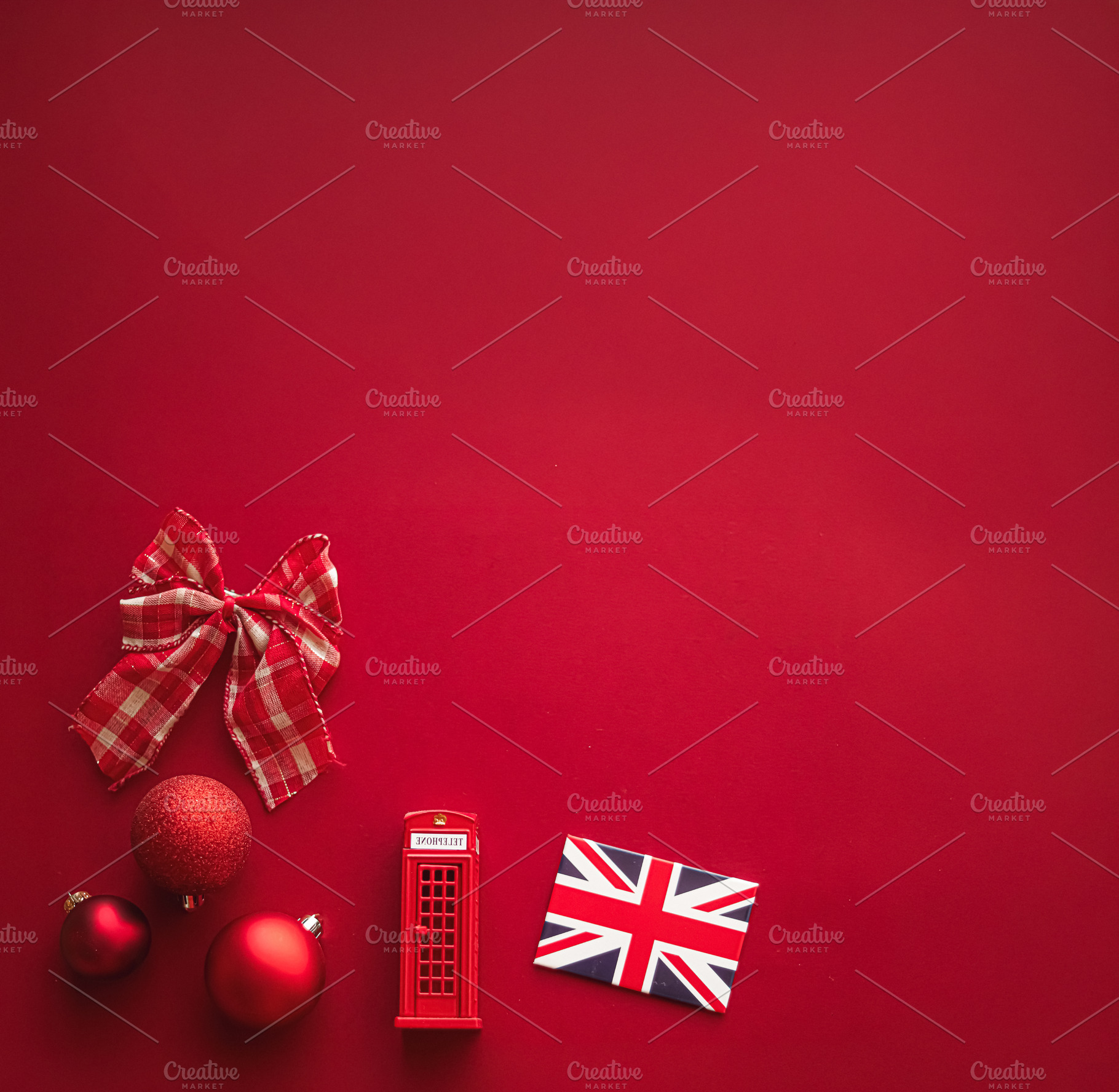 Christmas in London concept with Union Jack flag, red telephone box, bow, and b, a Photo by Studio ANNA