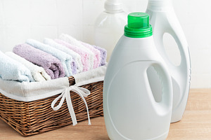 Laundry detergent bottles and clean folded towels, an Industrial Photo by Olena Rudo