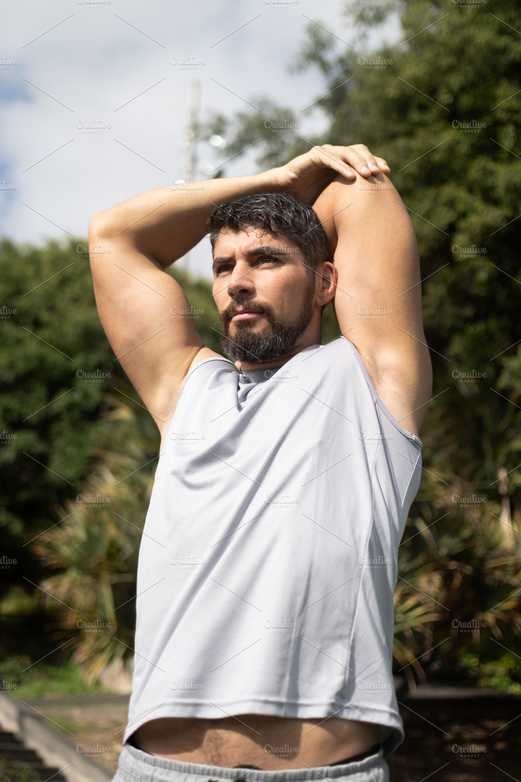 Young athletic man stretching outdoors in a park before workout, a Sports & Recreation Photo by etorres69