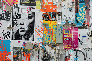 A Vibrant Urban Wall Covered In Layers Of Graffiti And Posters, Featuring A Str