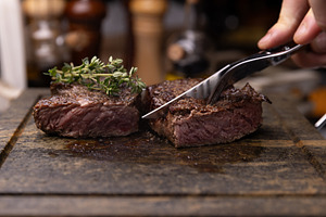 Steak on cutting board, garnished with fresh thyme, a Photo by Grafvision photography