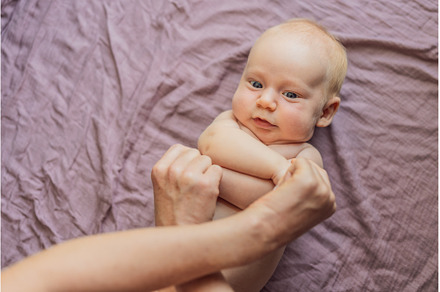 Newborn baby lying on a soft blanket