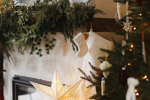 Stylish decorated christmas tree and fireplace mantel with stock, a Holiday Photo by Sonjachni