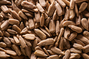 Peeled sunflower seeds filling the frame, creating a rustic background texture, a Photo by Studio ANNA