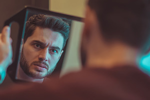 Evil guy looks in the mirror.