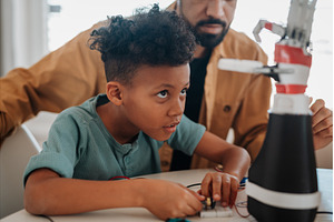 Father and son working on robotic, a Technology Photo by HalfPoint