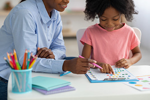 Closeup of cute black girl choosing colors on test board, a Photo by Prostock-Studio